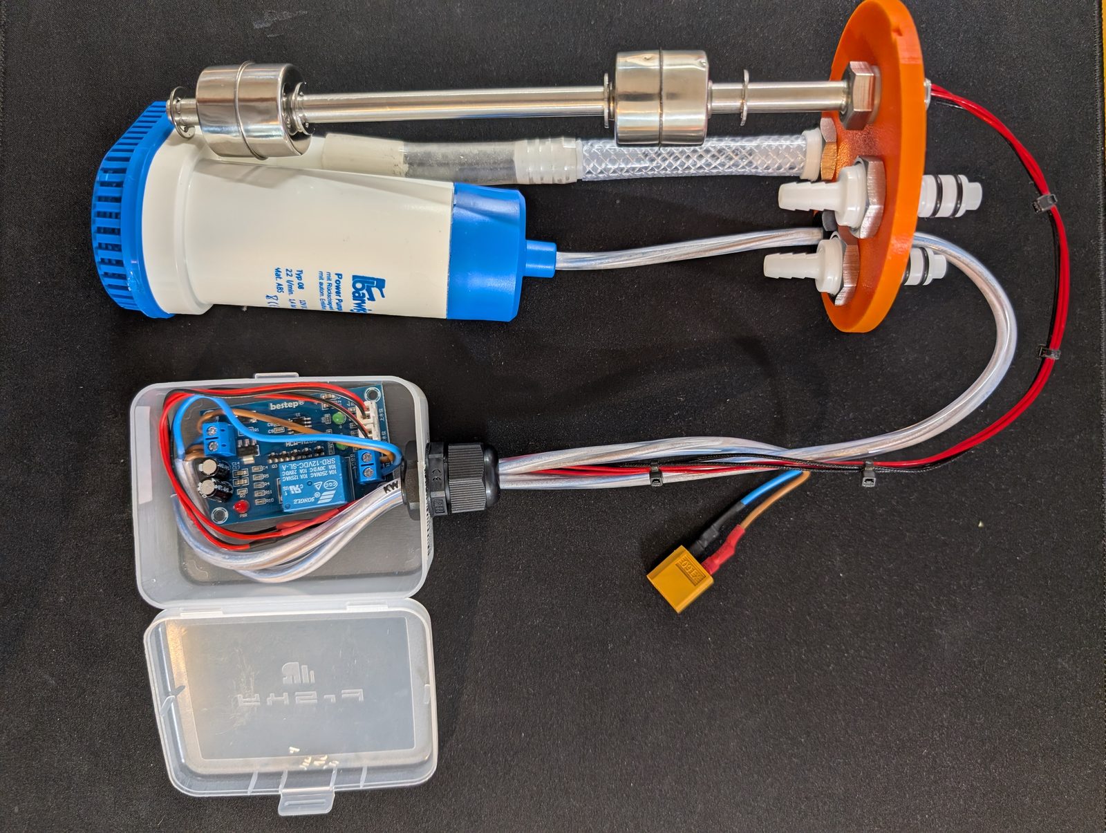 The whole machine, out of the pipe, on the table. This is the position it should never be in again. The complete internals laid out — pump, float switch, hoses, lid and controller