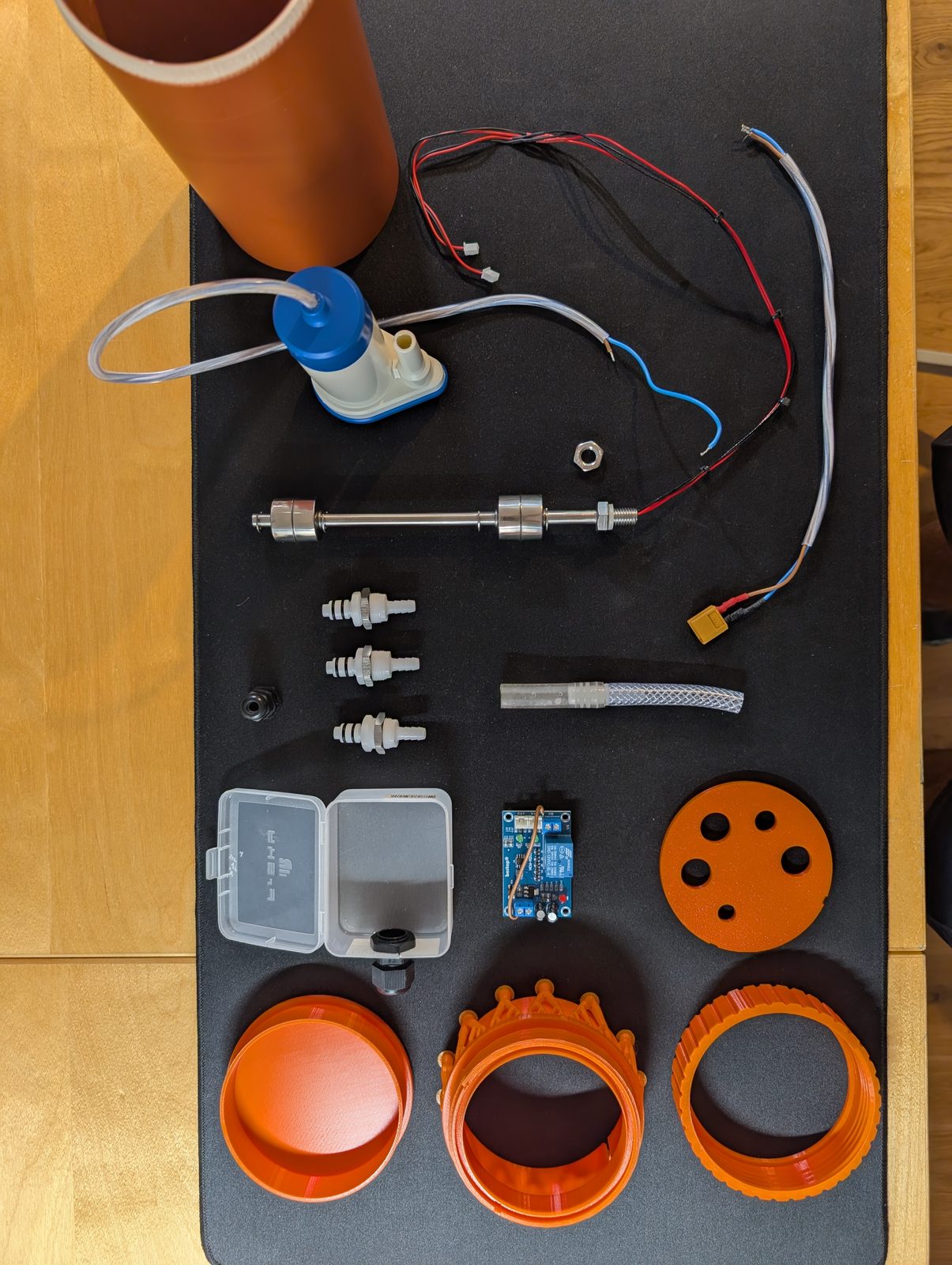Bill of materials, arranged for the photograph and never that tidy again. The four printed parts and everything else, laid out before assembly